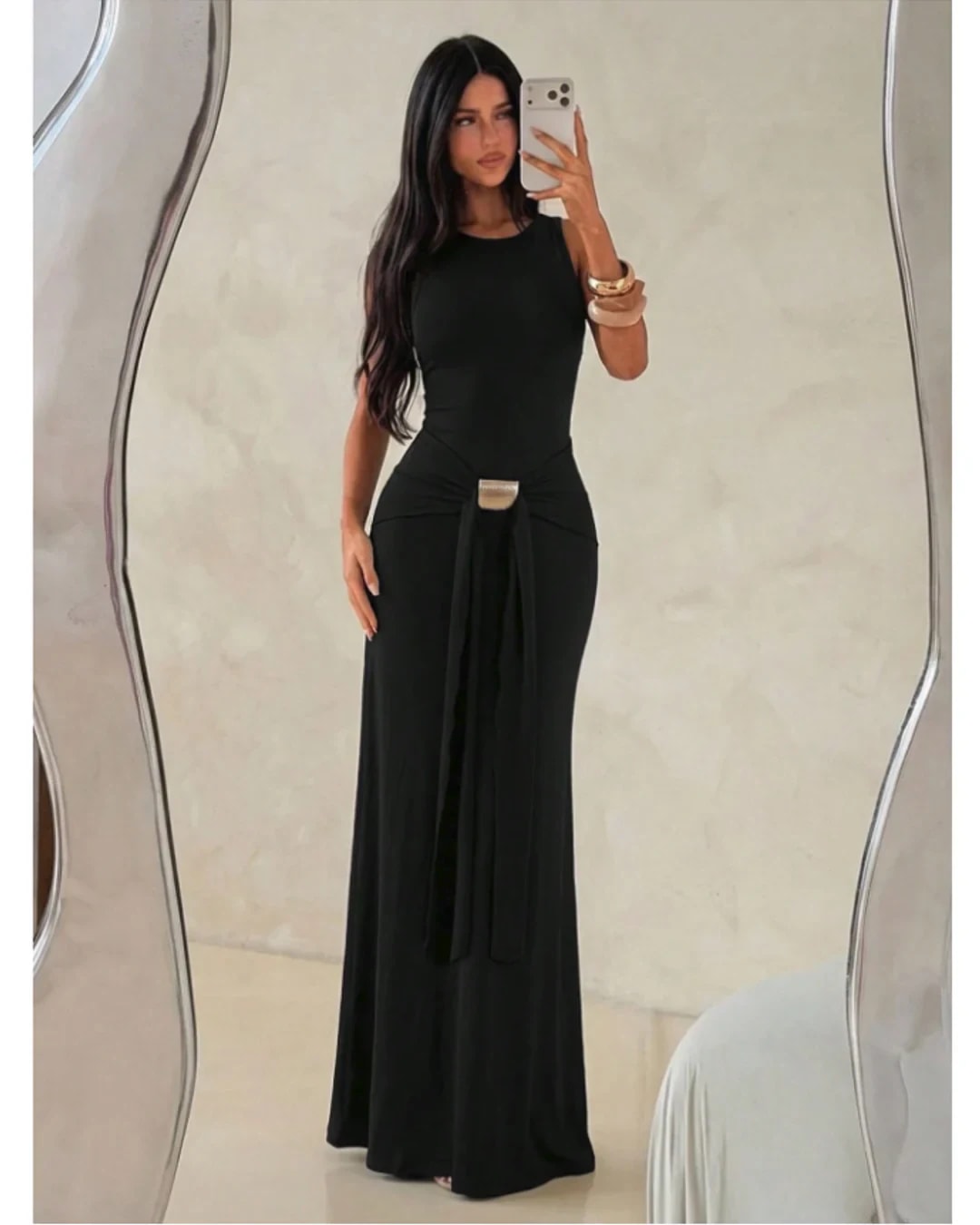 Modelo de cuerpo entero con vestido negro de espalda abierta y herraje dorado